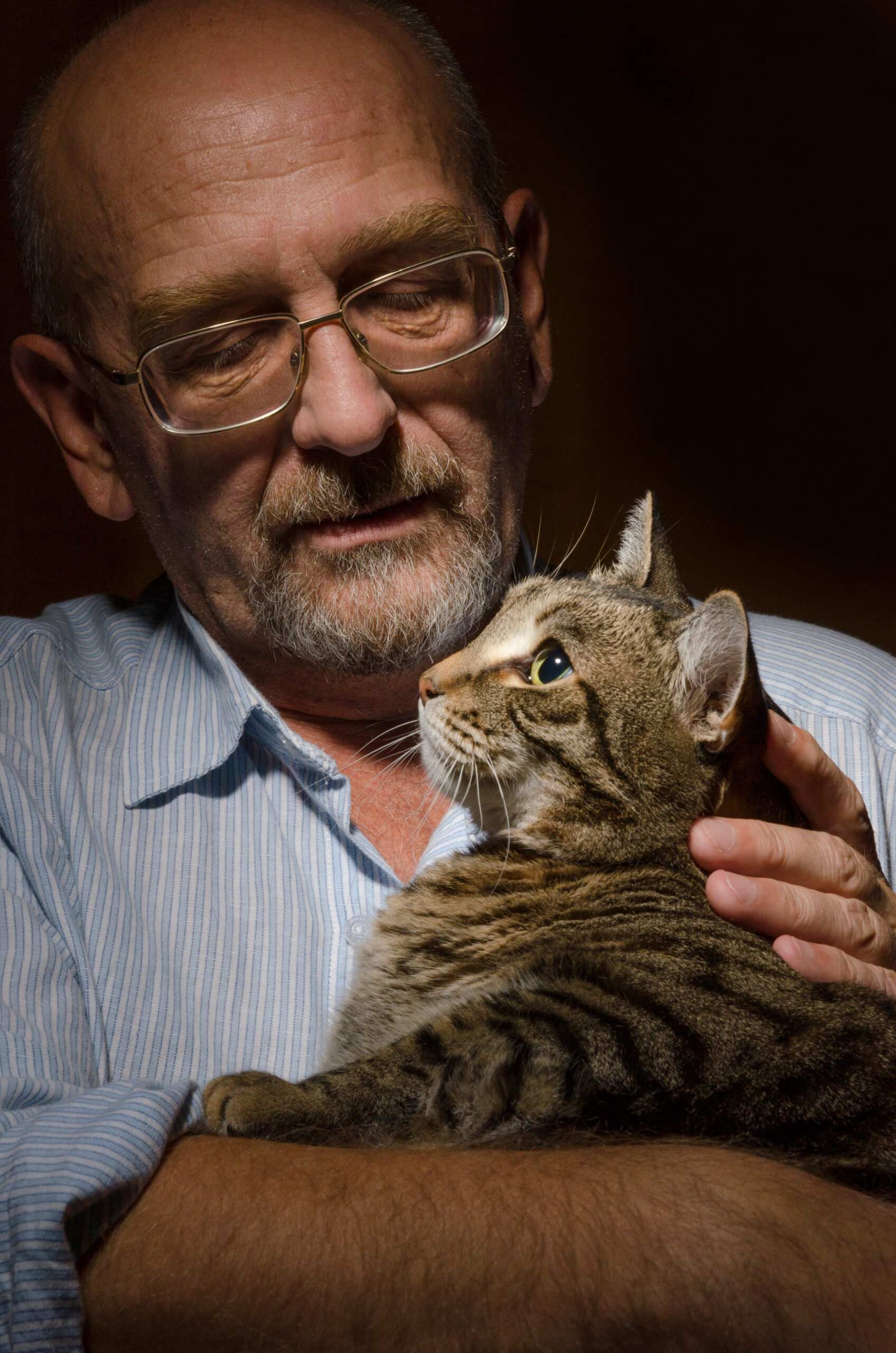 Low key shot of mature man with his cat